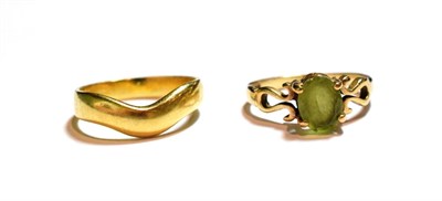 Lot 66 - An 18 carat gold band ring, finger size M1/2; and a 9 carat gold peridot ring, finger size M1/2
