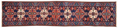 Lot 1096 - Narrow North West Persian Runner The deep indigo field with a column of terracotta and madder...