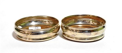 Lot 183 - A pair of silver bottle coasters with turned wooden bases, marked for London