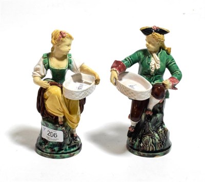 Lot 206 - A pair of late 19th century Minton Majolica figural salts, modelled as an 18th century gallant...