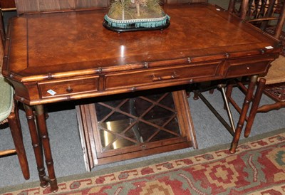 Lot 1220 - A reproduction burr wood and bamboo simulated writing table, with three drawers, 137cm wide