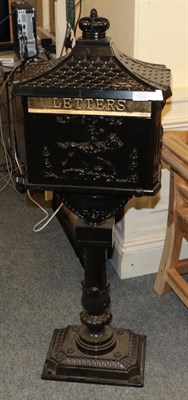 Lot 1227 - A free standing gloss black cast metal letter box, domed top, the box depicting a horse and...