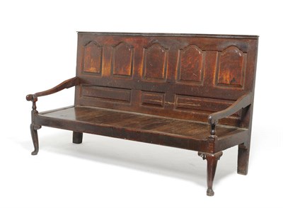 Lot 1154 - A George III Oak Settle, late 18th century, the back support with five fielded panels above...