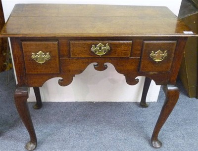 Lot 1164 - A George II Oak Kneehole Dressing Table, mid 18th century, with three frieze drawers above a...