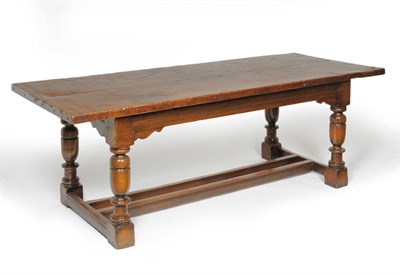 Lot 1165 - A Joined Oak Refectory Dining Table, the burr oak rectangular top with moulded frieze, on...