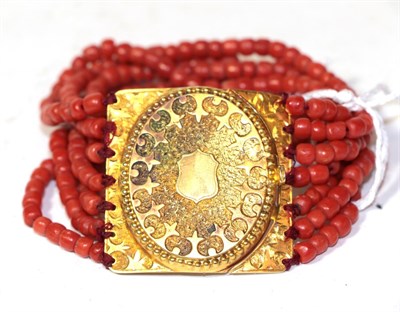 Lot 283 - A seven stranded coral bracelet, with yellow plaque clasp, length 16.5cm