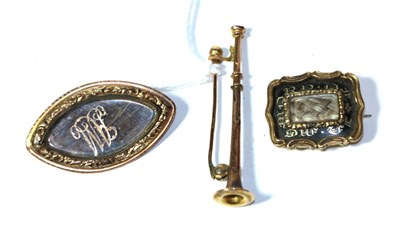 Lot 294 - Two Victorian hairwork mourning brooches; and a trumpet form brooch, stamped '9' and '.375'