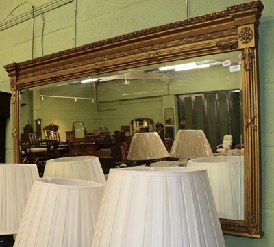 Lot 417 - A reproduction gilt over mantle mirror with bevelled glass plate, 82cm by 152cm