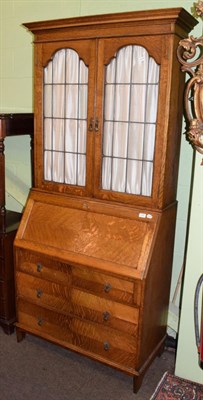 Lot 432 - A 1920s oak bureau bookcase with leaded glass doors, 92cm wide