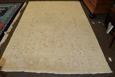 Lot 450 - An Indian rug of Agra design, the cream field of serrated leafy vines enclosed by floral...