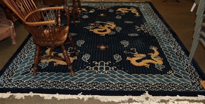 Lot 454 - A Chinese carpet, the indigo field with dragon chasing a flaming pearl, the spandrels similar,...