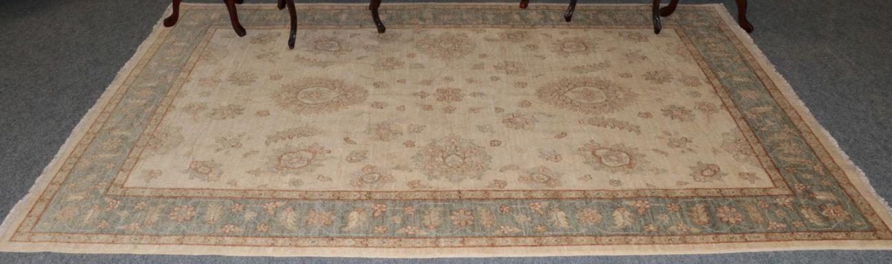 Lot 457 - An Afghan Ziegler rug, the ivory field of flower heads and vines enclosed by meandering vine...
