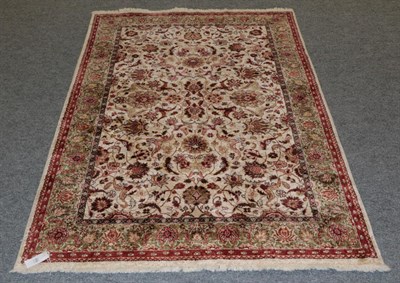 Lot 459 - A Chinese silk rug, the ivory field with an all over design of palmettes and vines, enclosed by...