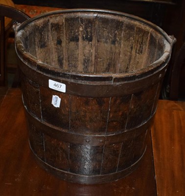 Lot 467 - A staved oak and metal bound bucket with carrying handle, 33cm high; together with an oak rush...