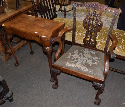 Lot 521 - A 20th century walnut card table; together with a finely carved carver