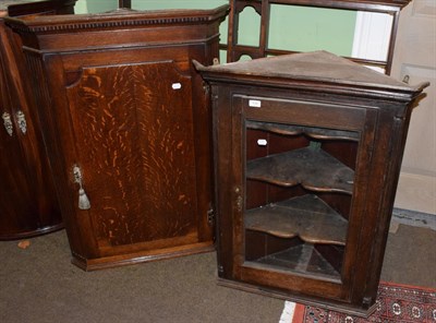 Lot 536 - A George III oak hanging corner cupboard, with fluted stiles; and a glazed oak example (2)