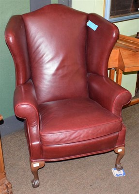 Lot 544 - A red leather wing back chair on claw feet