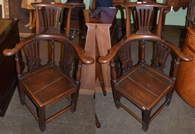 Lot 549 - A pair of George III style oak elbow chairs with solid seats