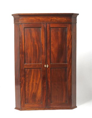 Lot 1273 - A George III Mahogany Hanging Corner Cabinet, early 19th century, with two fielded panel doors...