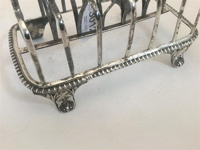 Lot 3012 - A George III Silver Toastrack, by Rebecca Emes and Edward Barnard, London, 1815, oblong and on four