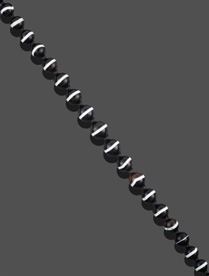 Lot 3255 - A Sardonyx Necklace, thirty-three graduated spherical sardonyx beads spaced by smaller black beads