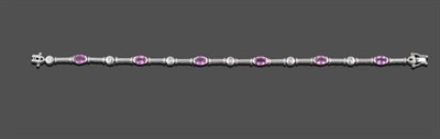 Lot 3268 - A Pink Sapphire and Diamond Bracelet, six oval cut pink sapphires in white broad claw settings...
