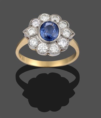 Lot 3301 - A Sapphire and Diamond Cluster Ring, an oval cut sapphire within a border of round brilliant...