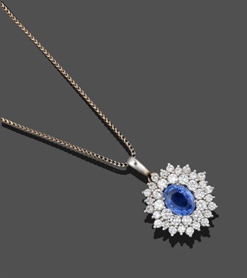 Lot 3303 - A Sapphire and Diamond Cluster Pendant on An 18 Carat White Gold Chain, an oval cut sapphire within