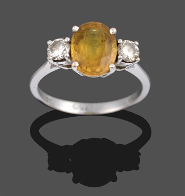 Lot 3306 - An 18 Carat White Gold Yellow Sapphire and Diamond Three Stone Ring, the oval cut yellow...