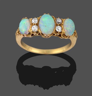 Lot 3325 - An Opal and Diamond Ring, three graduated oval cabochon opals spaced by pairs of old cut...