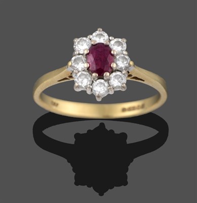 Lot 3332 - An 18 Carat Gold Ruby and Diamond Cluster Ring, an oval cut ruby within a border of round brilliant