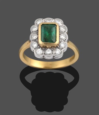 Lot 3336 - An 18 Carat Gold Emerald and Diamond Cluster Ring, an emerald-cut emerald in a yellow rubbed...