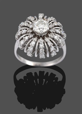 Lot 3348 - A Diamond Cluster Starburst Ring, a round brilliant cut diamond within a frame of curved rows...