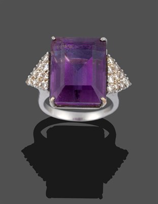 Lot 3358 - An 18 Carat White Gold Amethyst and Diamond Ring, the step cut amethyst flanked by a triangular...
