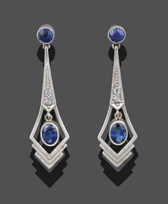 Lot 3365 - A Pair of Sapphire and Diamond Drop Earrings, a round cut sapphire in a white millegrain...