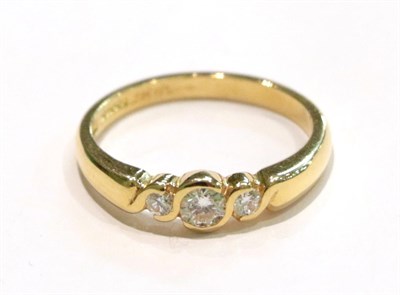 Lot 213 - An 18 carat gold diamond three stone ring, the graduated round brilliant cut diamonds in yellow...