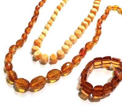 Lot 233 - A faceted graduated amber bead necklace, length 91cm; an amber simulant bracelet; two pairs of...