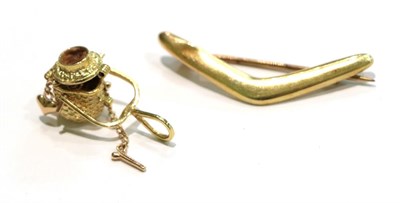 Lot 246 - A boomerang brooch, stamped '9', length 3.8cm; and a basket charm, unmarked