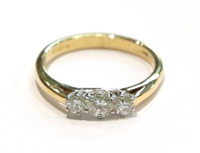 Lot 252 - An 18 carat gold diamond three stone ring, the graduated round brilliant cut diamonds in white claw