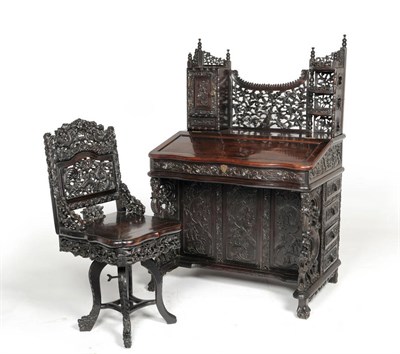 Lot 1327 - A Chinese Hardwood Carved Desk, circa 1900, with foliate carved superstructure and hinged...