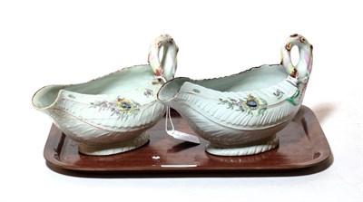 Lot 324 - A pair of Worcester porcelain cos lettuce leaf sauceboats, circa 1755, painted with flower...