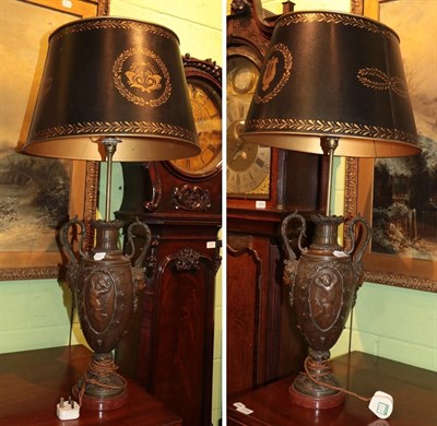 Lot 354 - A pair of patinated metal Classical style table lamps with simulated toleware shades