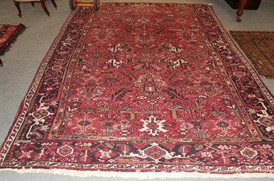 Lot 1143 - A Heriz carpet, the tomato field of serrated leafy vines enclosed by samovar motif borders,...
