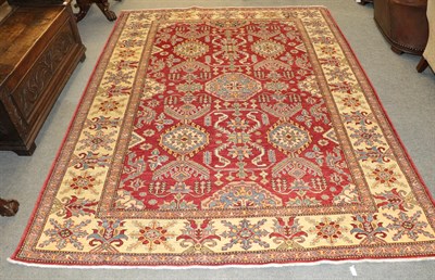 Lot 1152 - An Afghan rug, the blood red field centred by an octagon surrounded by geometric motifs framed...