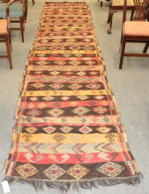 Lot 1159 - Anatolian Kilim runner, the field with polychrome bands of geometric devices, 465 by 94cm