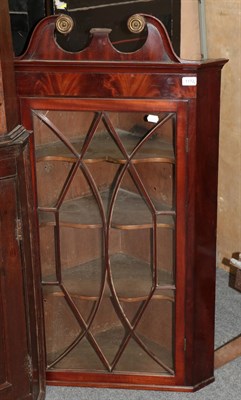 Lot 1172 - A Georgian mahogany astragal glazed hanging corner cupboard, with broken pediment, with three...