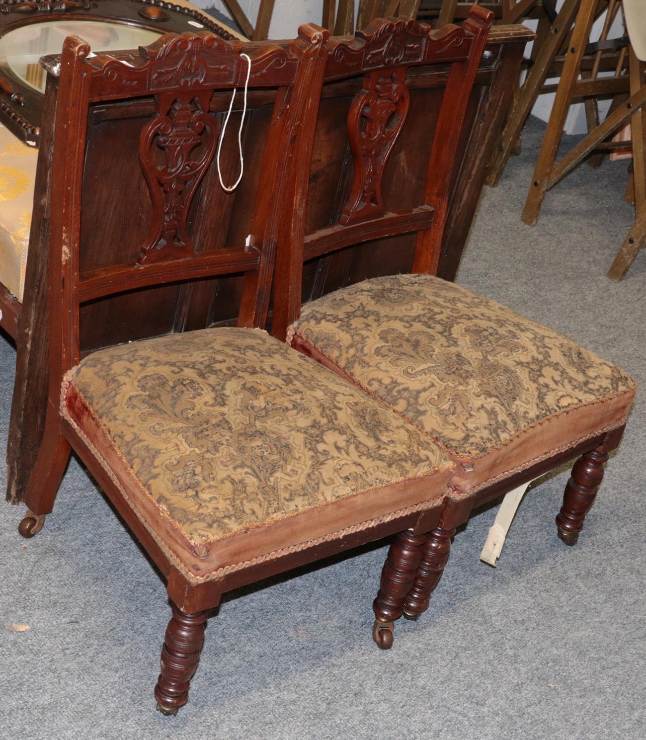 Lot 1179 - A pair of Edwardian nursing chairs, pierced splats, overstuffed seats, turned front legs to...