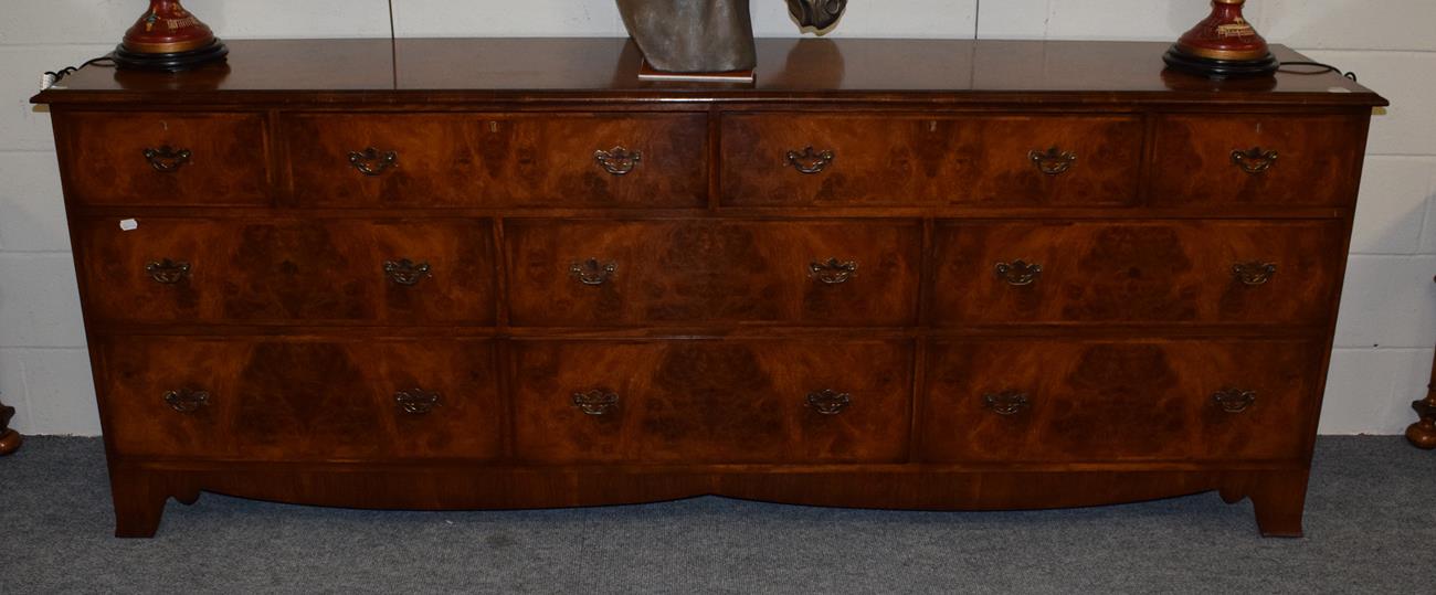 Lot 1195 - A walnut and feather banded sideboard with an arrangement of drawers, 241cm wide