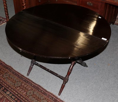 Lot 1270 - An early 20th century ebonised coaching table by Thornton Herne, 95cm diameter (extended)