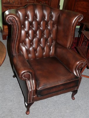 Lot 1273 - Wing back armchair upholstered in brown close-nailed leather, 84cm wide